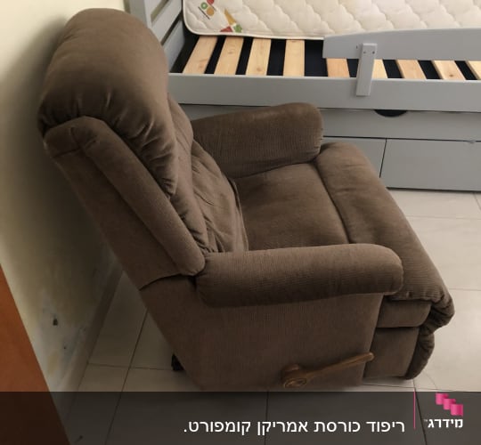 כורסה מרופדת חומה ליד מיטה עם מזרן